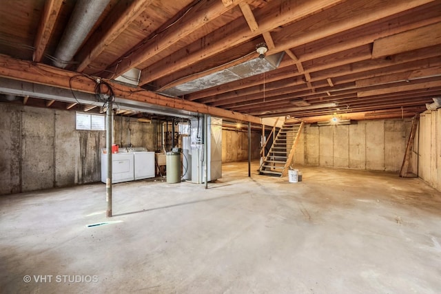 basement featuring heating unit, washing machine and dryer, and stairs