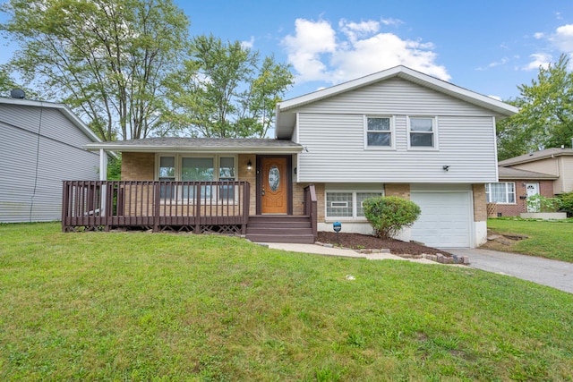 tri-level home with a garage, a front yard, concrete driveway, and brick siding