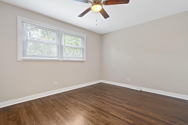 spare room featuring visible vents, dark wood finished floors, baseboards, and ceiling fan