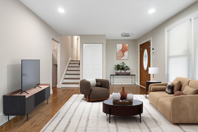 living area featuring stairs, baseboards, wood finished floors, and recessed lighting