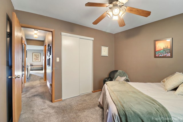 bedroom featuring baseboards, a ceiling fan, a closet, and light colored carpet