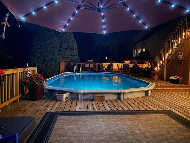 pool at night with an outdoor pool and a deck