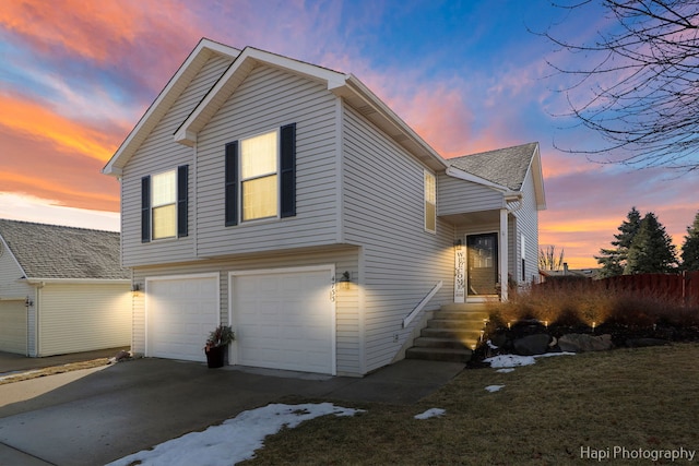 view of side of property with a shingled roof, driveway, and an attached garage