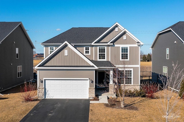 craftsman inspired home featuring an attached garage, driveway, stone siding, roof with shingles, and board and batten siding