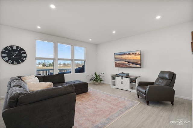 living area featuring light wood-style floors, baseboards, and recessed lighting