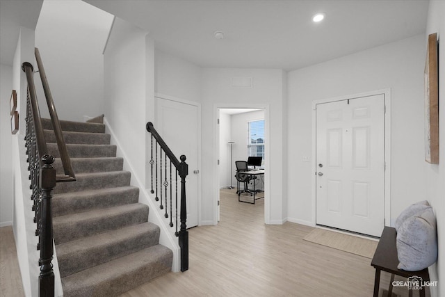 entrance foyer with baseboards, light wood finished floors, stairway, and recessed lighting