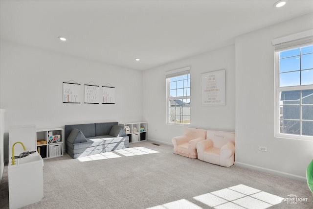 living room featuring baseboards, recessed lighting, and light colored carpet