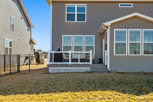 back of property featuring a deck, a yard, and fence