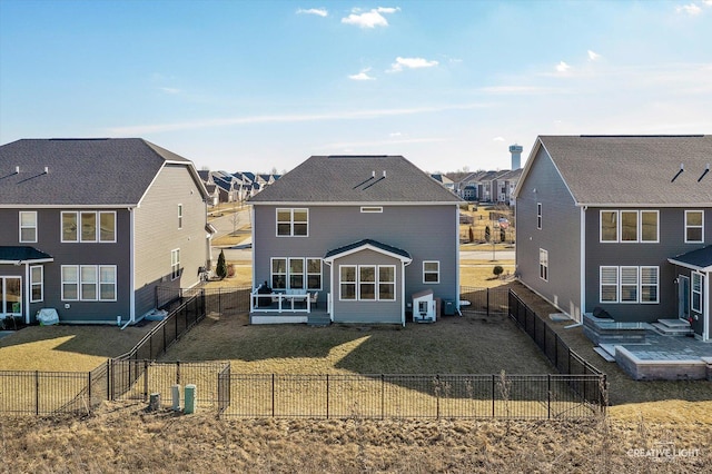 back of property with a lawn, a fenced backyard, and a residential view