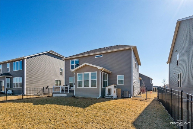 back of property with a fenced backyard, a yard, and central air condition unit