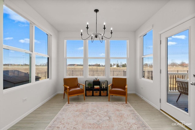 sunroom / solarium featuring a notable chandelier