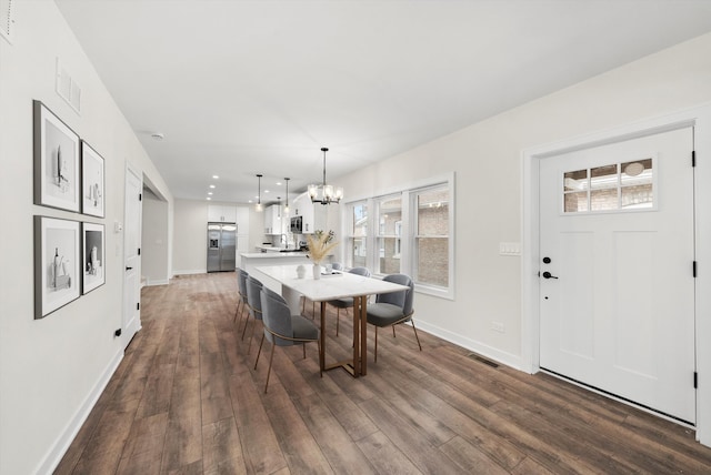 dining room featuring dark hardwood / wood-style flooring and a chandelier