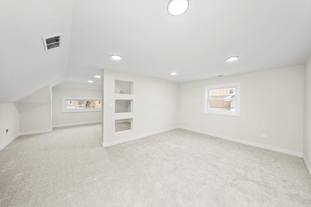 interior space featuring lofted ceiling and light carpet