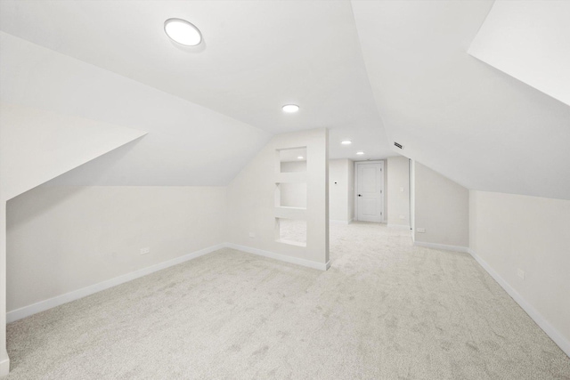 bonus room with light colored carpet and lofted ceiling