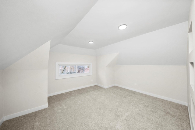 bonus room featuring lofted ceiling and light carpet