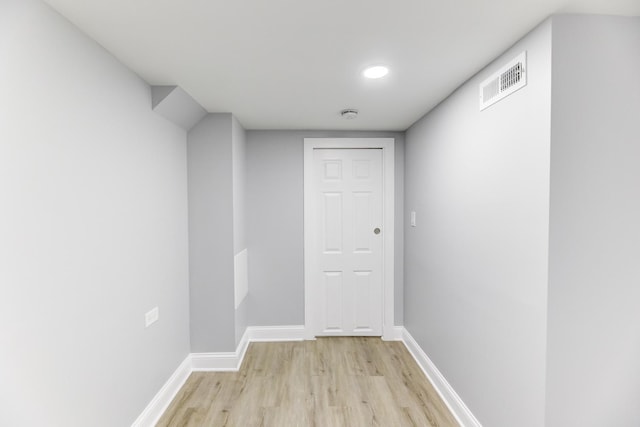 hallway with light hardwood / wood-style floors