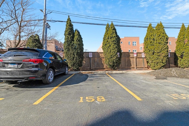 uncovered parking lot featuring fence