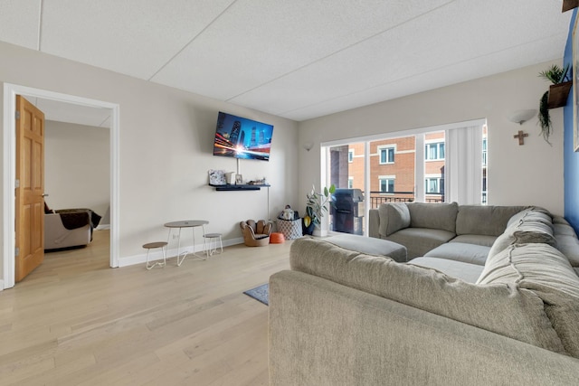 living area with light wood-style flooring and baseboards