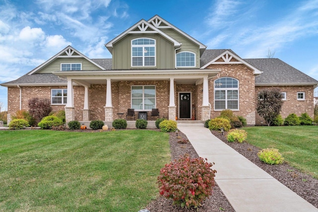 craftsman house featuring covered porch and a front yard