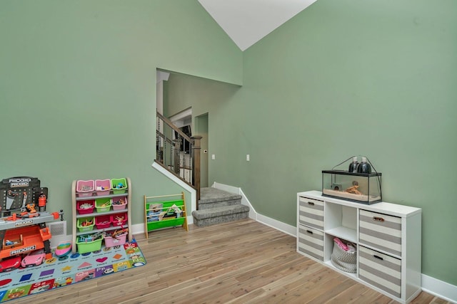 rec room featuring high vaulted ceiling and hardwood / wood-style flooring