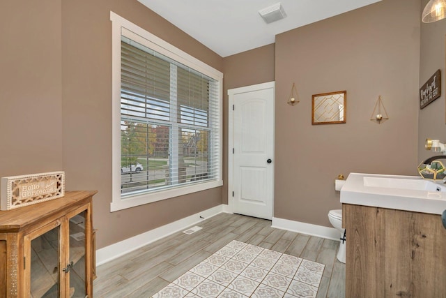 bathroom featuring toilet, hardwood / wood-style flooring, and vanity