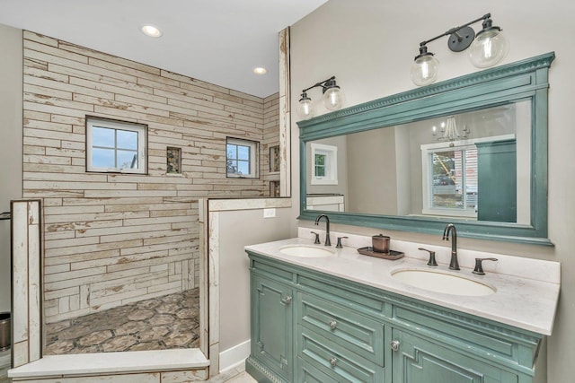 bathroom featuring tiled shower and vanity