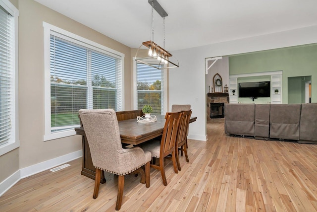 dining room featuring a fireplace and light hardwood / wood-style floors