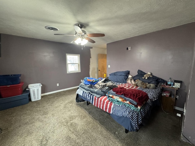 bedroom featuring ceiling fan, a textured ceiling, and dark colored carpet