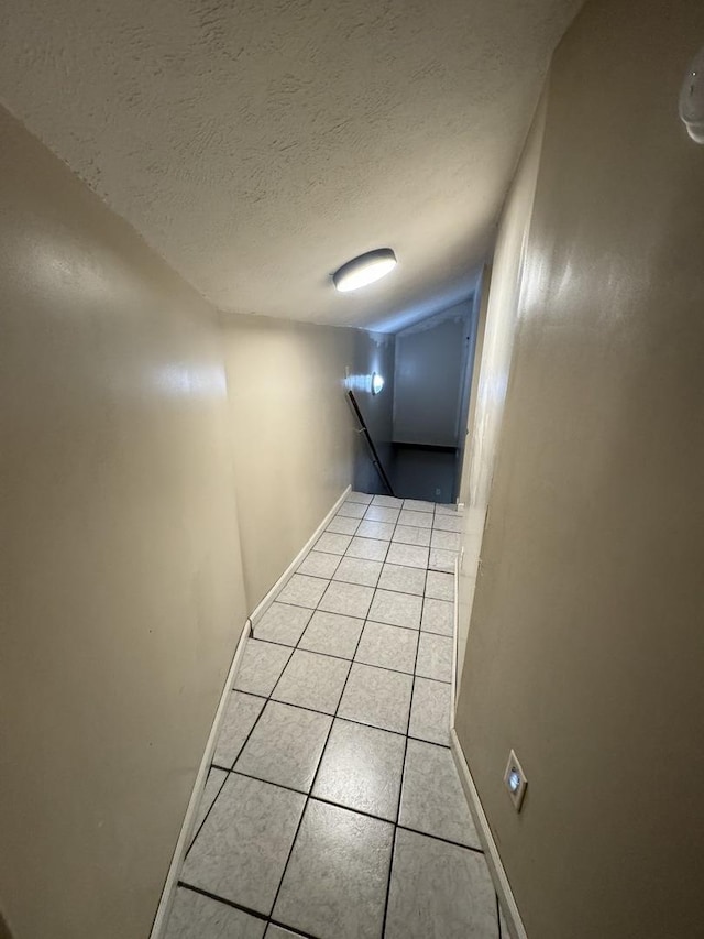 hallway with light tile patterned flooring and a textured ceiling