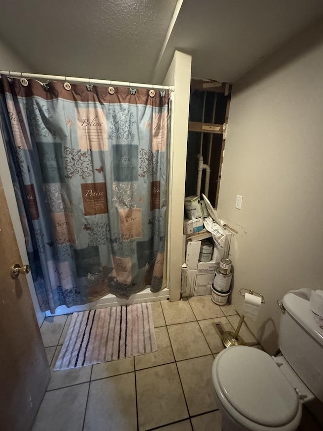 bathroom featuring a shower with curtain, tile patterned floors, a textured ceiling, and toilet