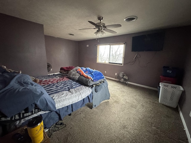 carpeted bedroom featuring ceiling fan and a textured ceiling