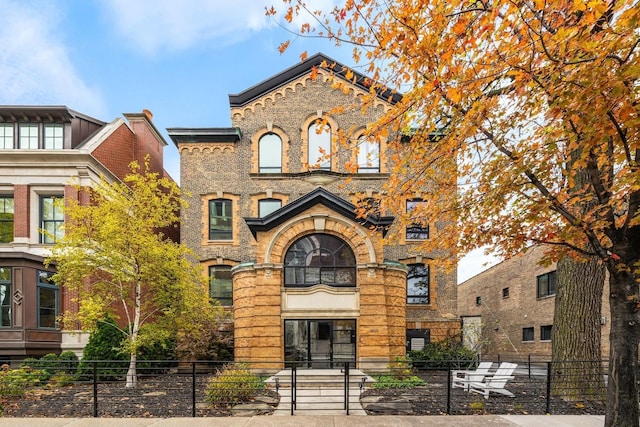 view of front facade with brick siding and a fenced front yard