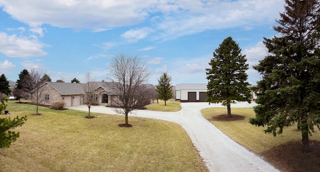 view of front facade featuring a front yard, curved driveway, and an attached garage