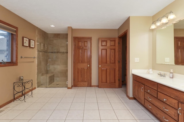 full bathroom featuring a stall shower, tile patterned flooring, baseboards, and vanity