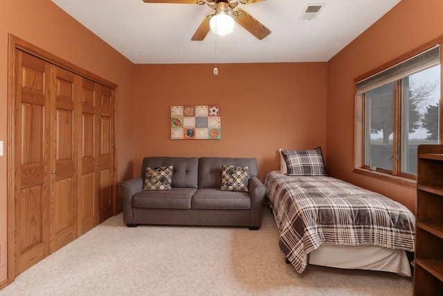 bedroom with a ceiling fan, carpet, visible vents, and a closet