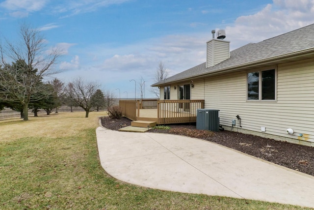 view of yard with a patio, central AC unit, and a wooden deck