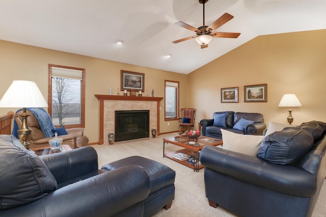 living room featuring light carpet, baseboards, ceiling fan, vaulted ceiling, and a fireplace