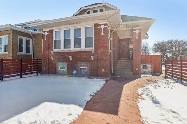 view of front facade with brick siding and fence