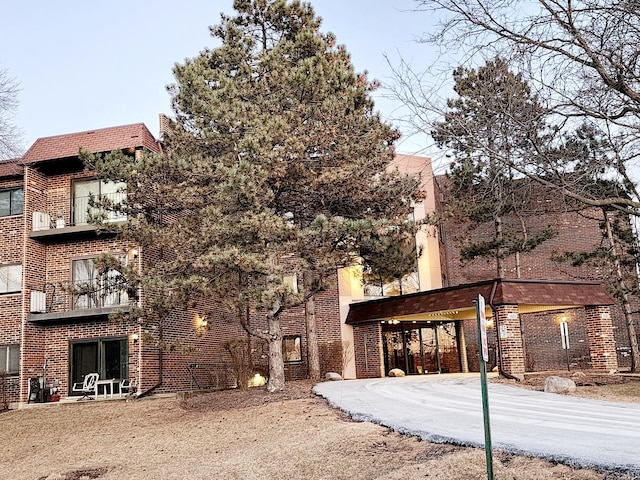 exterior space with a balcony and brick siding