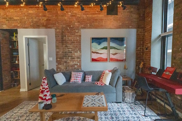 living room featuring brick wall and track lighting