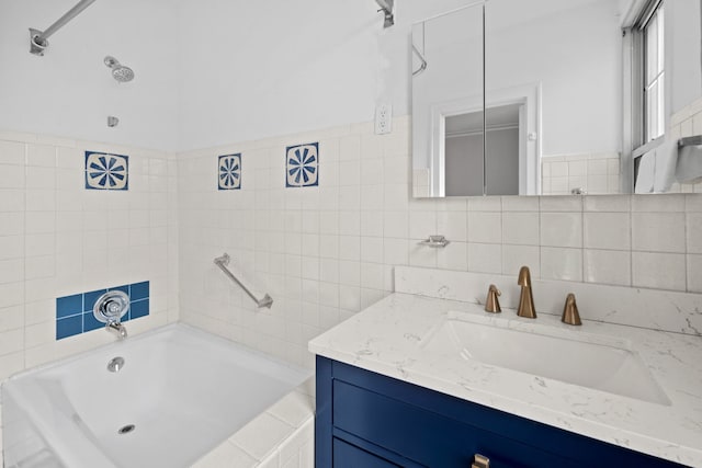 bathroom featuring vanity, a tub, and tile walls