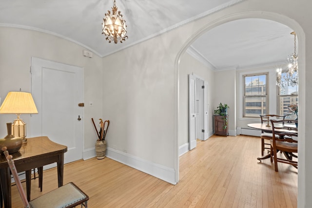 entrance foyer featuring wood-type flooring, lofted ceiling, a chandelier, ornamental molding, and baseboard heating