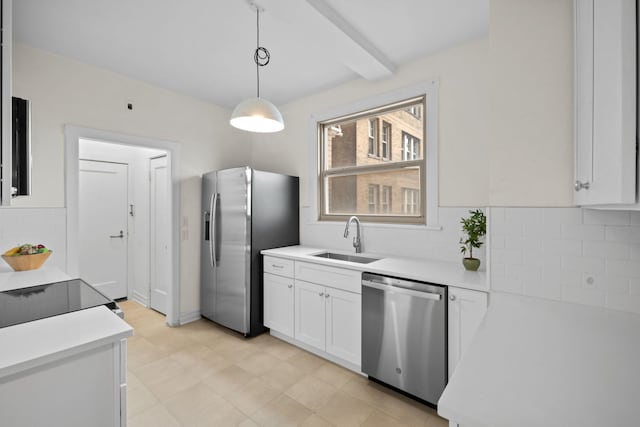 kitchen with pendant lighting, white cabinetry, sink, backsplash, and stainless steel appliances