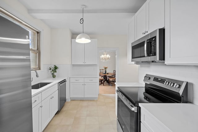 kitchen with white cabinetry, sink, backsplash, hanging light fixtures, and stainless steel appliances