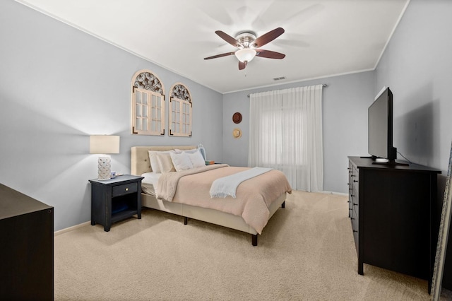 bedroom with ceiling fan, ornamental molding, and light carpet