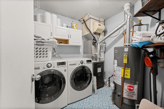 clothes washing area featuring cabinets, gas water heater, and separate washer and dryer