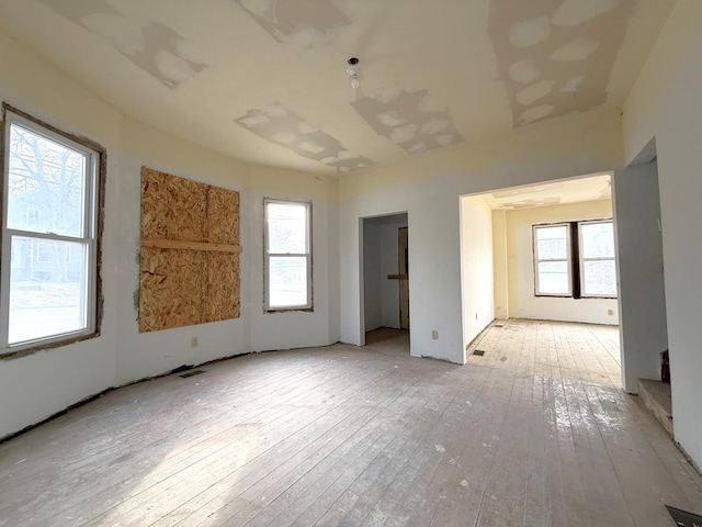 spare room with a healthy amount of sunlight and light hardwood / wood-style floors