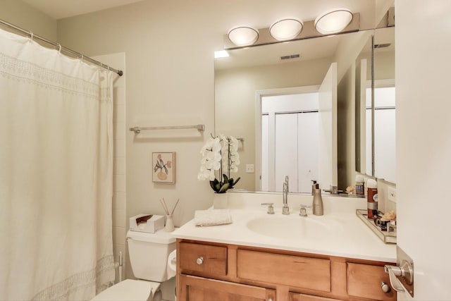 bathroom featuring vanity, walk in shower, and toilet