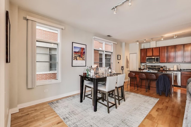 dining space with light hardwood / wood-style flooring and plenty of natural light