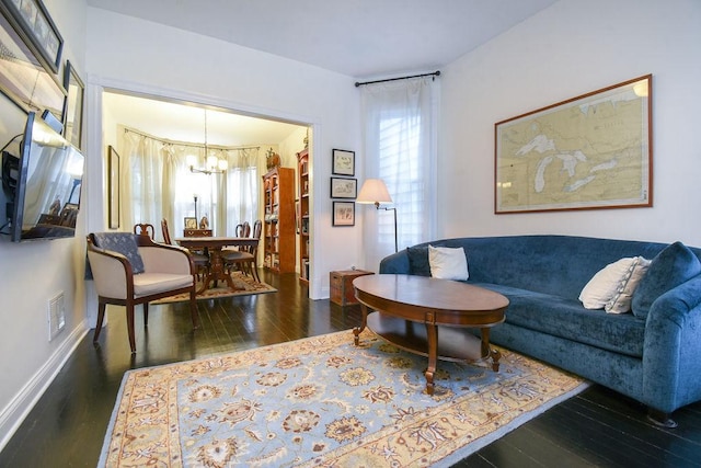 living room with dark hardwood / wood-style floors and a notable chandelier